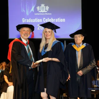 Graduates in caps and gowns receive diplomas at Fairfield School of Business graduation ceremony 2023
