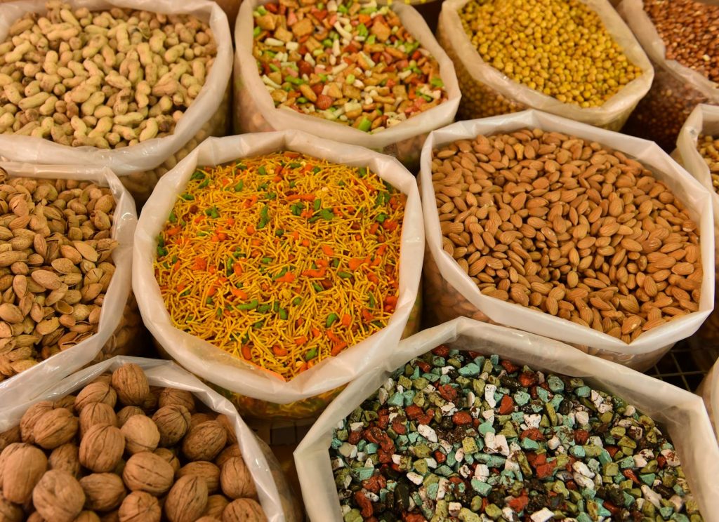 Variety of nuts and spices displayed in bags, showcasing colorful and diverse food options
