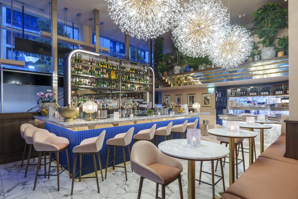 Modern bar interior with stylish seating, marble surfaces, and vibrant lighting in a chic restaurant setting